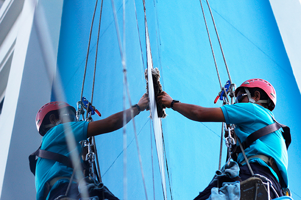 Reinigung einer Glasfassade. Mann mit Schutzhelm